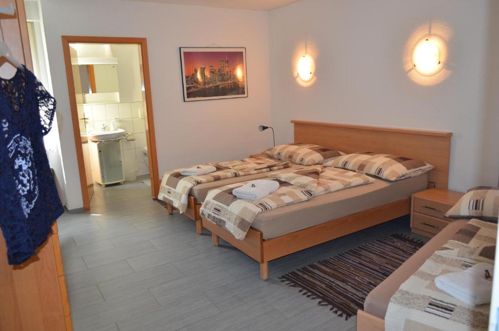 Una cama o camas en una habitación de Don Camillo Gästehaus