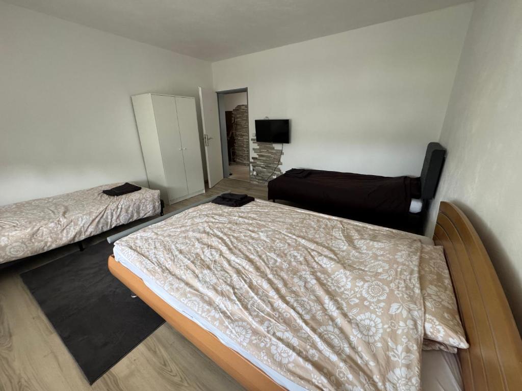 a room with two beds and a television in it at Moderne Zimmer nähe A3 in Ransbach-Baumbach