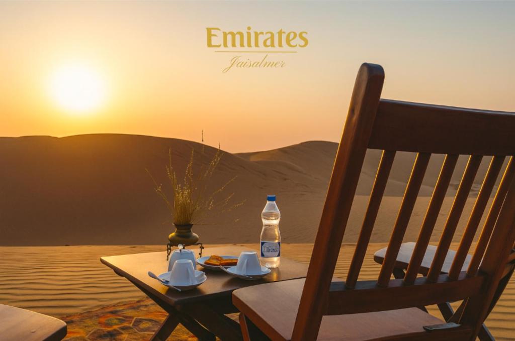 a table with a bottle of water and a chair at Luxury Desert Camping in Jaisalmer