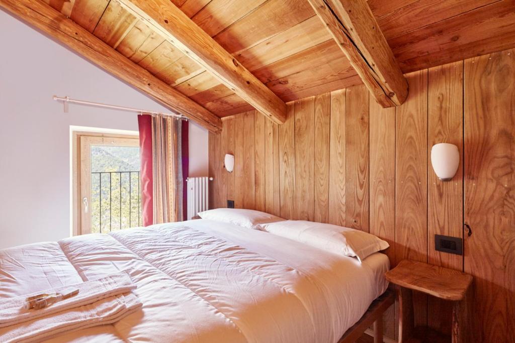 a bedroom with a large bed with wooden walls at Locanda Del Silenzio Residence in Macra