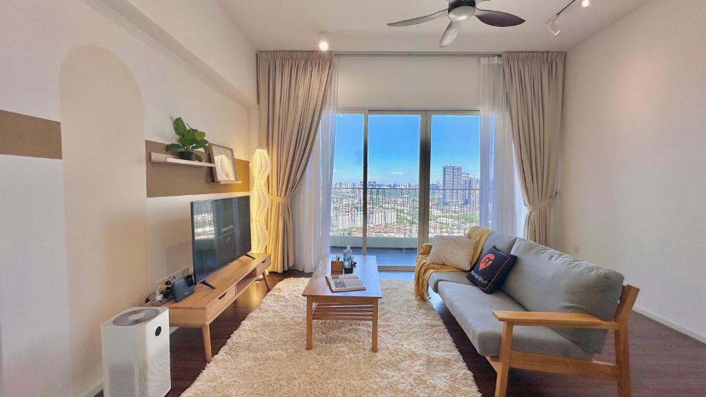 a living room with a couch and a large window at UNA Serviced Apartment by manatidur in Kuala Lumpur