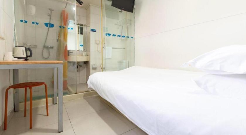 ein weißes Schlafzimmer mit einem Bett und einer Dusche in der Unterkunft Bestay Hotel Express Nanjing Xinjiekou in Nanjing