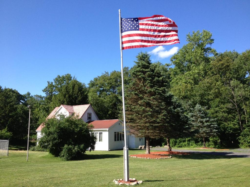 uma bandeira americana num poste em frente a uma casa em Echo Valley Cottages em Coolbaugh