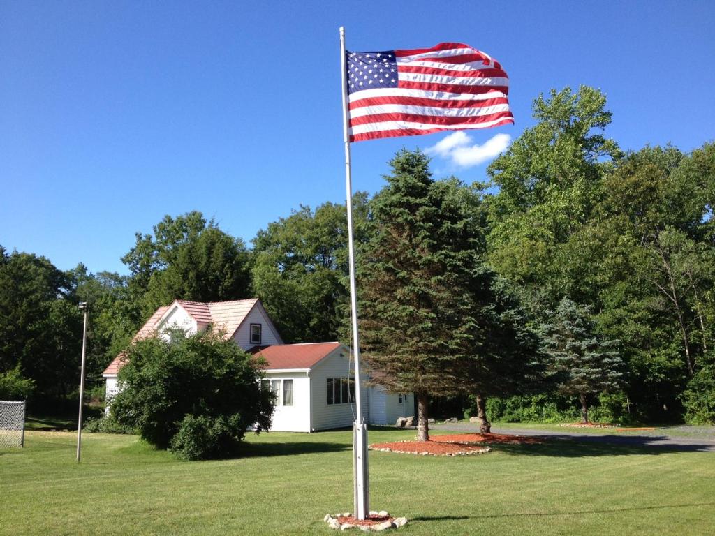 an american flag on a pole in front of a house at Echo Valley Cottages in Coolbaugh