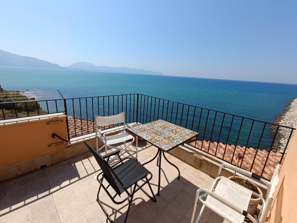 a table and chairs on a balcony overlooking the ocean at Finestra sul golfo in Balestrate