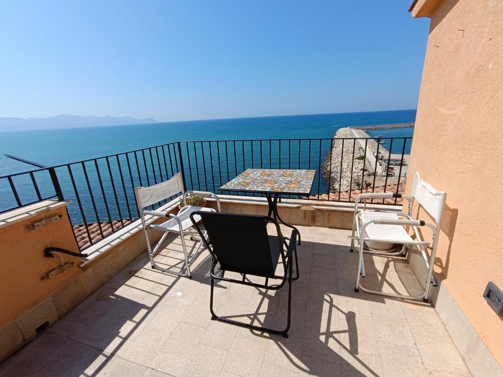 a balcony with chairs and a table and the ocean at Finestra sul golfo in Balestrate