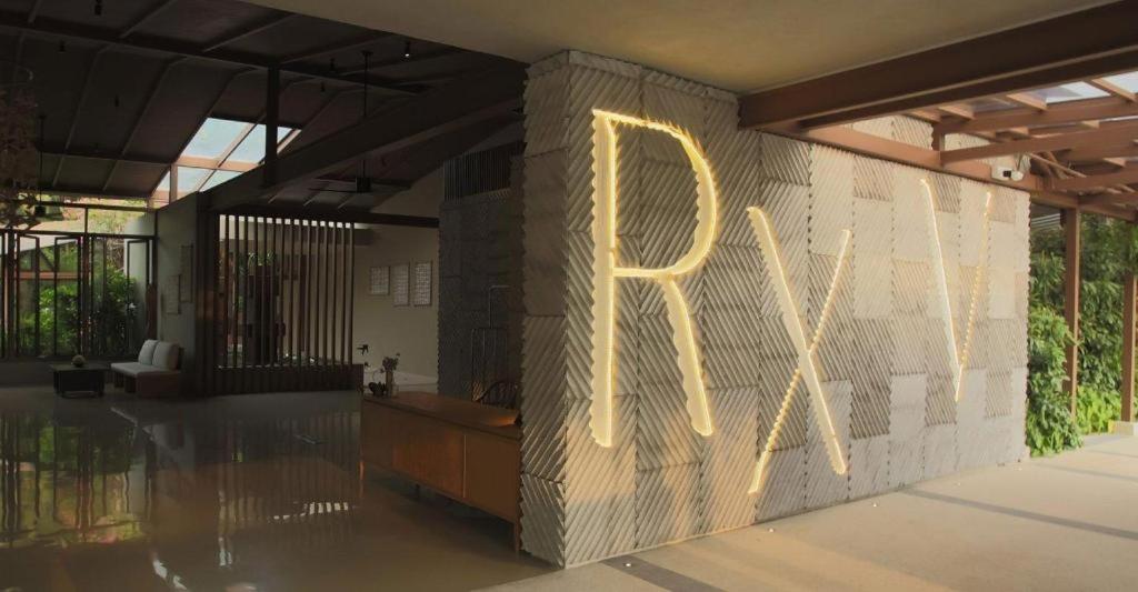 ein Schild mit der Aufschrift „RX“ an einer Ziegelmauer in der Unterkunft RXV Wellness Village in Ban Bang Yai Chuai