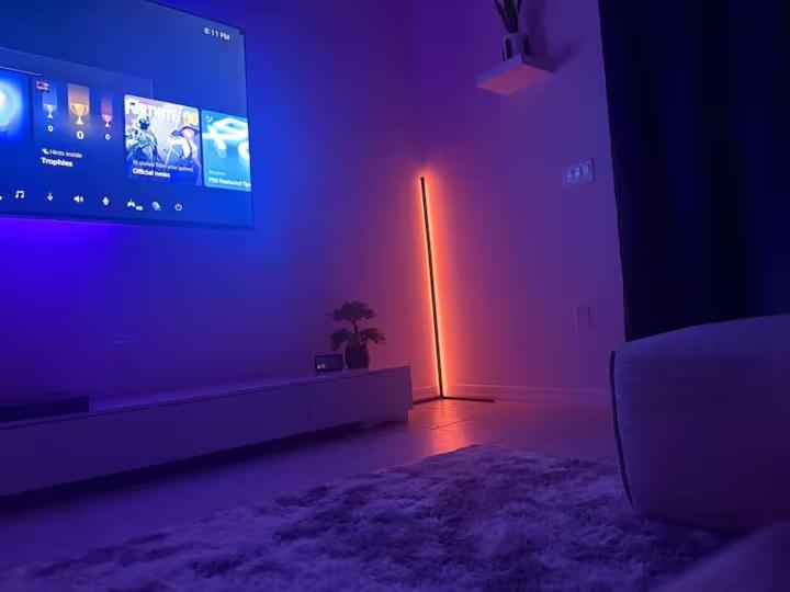 a living room with a large tv and purple lights at Modern Winter Villa Home Near Disney and Lego Land! in Haines City