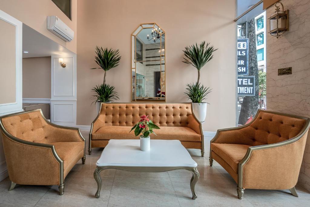 a waiting room with a couch and two chairs and a table at SAZI RESIN HOTEL - Free Nails HairWash in Ho Chi Minh City