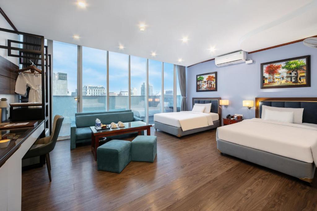 una camera d'albergo con due letti e un divano di A25 Hotel - 12 Ngô Sỹ Liên a Hanoi