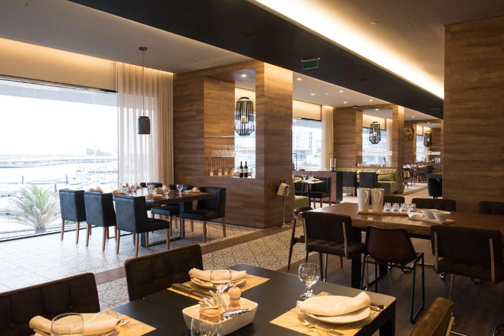 a restaurant with tables and chairs and a large window at Octant Ponta Delgada in Ponta Delgada