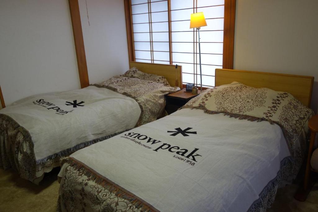 zwei Betten in einem Zimmer mit der Aufschrift „Show Park“ darauf in der Unterkunft Natural Mind Tour - Vacation STAY 56703v in Sado