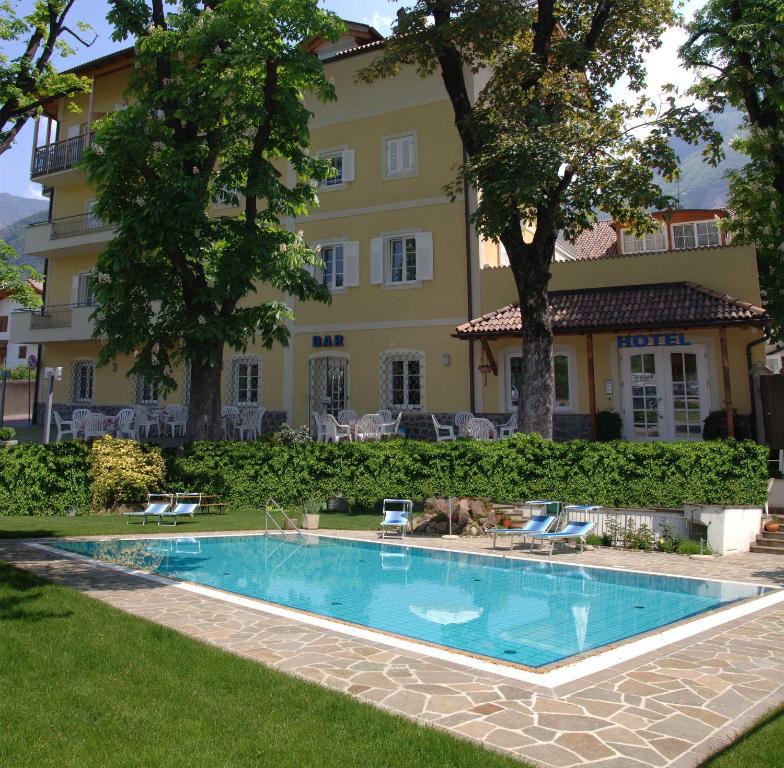 a swimming pool in front of a building at Hotel Stampfer B&B in Laives