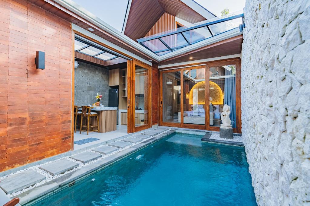 an indoor swimming pool in a house with a patio at iRini Villas in Nusa Dua