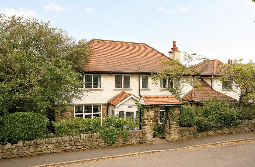 ein großes weißes Haus mit einer Steinmauer in der Unterkunft Vintage vibe with modern conveniences - Sheffield & Peak District! in Stannington