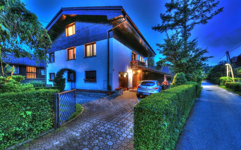 une maison avec une voiture garée devant elle dans l'établissement Guesthouse Marko, à Bled