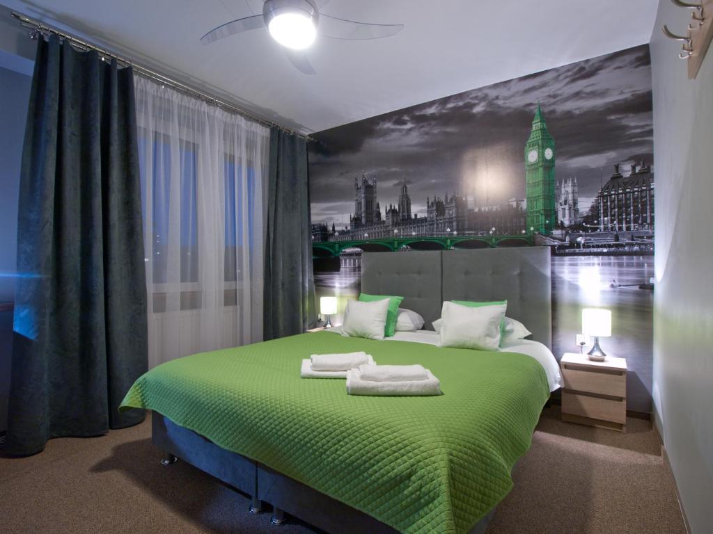1 dormitorio con 1 cama verde con vistas a la ciudad en Apartamenty studio Metropolio Centrum, en Białystok