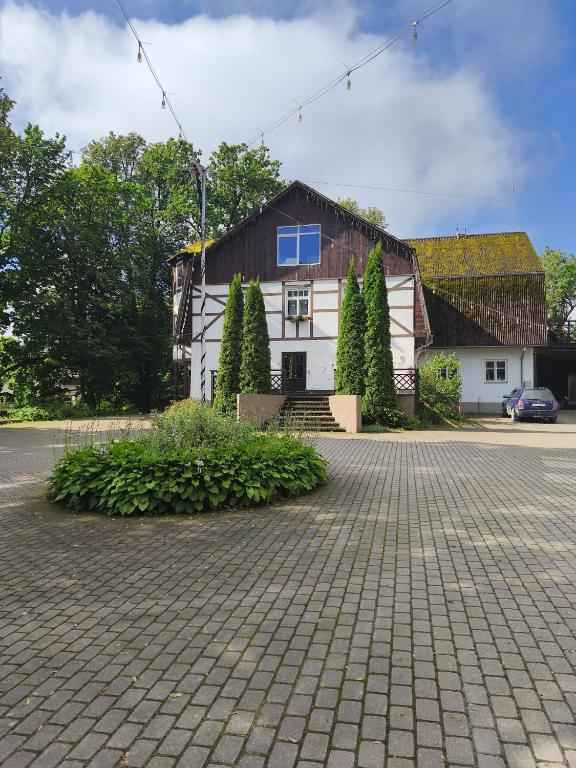 a large white building with a blue window on it at Baltakmeņu muiža in Mujani