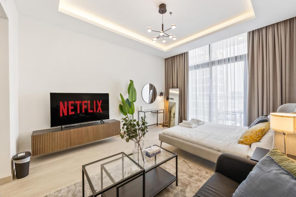 a living room with a couch and a tv at Elite Escape - Getaway in Azizi Riviera 13 in Dubai