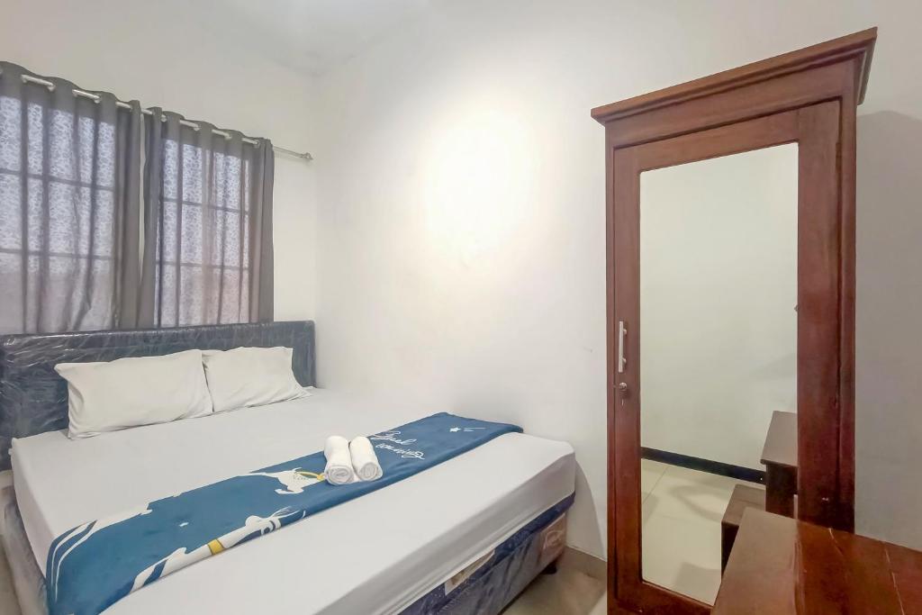 Ένα ή περισσότερα κρεβάτια σε δωμάτιο στο Pasadena House Semarang Mitra RedDoorz