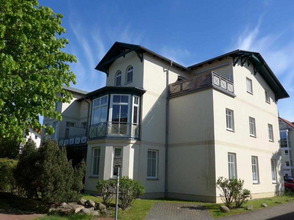 a white house with a black roof at Fewo Anker in der Villa Victoria in Graal