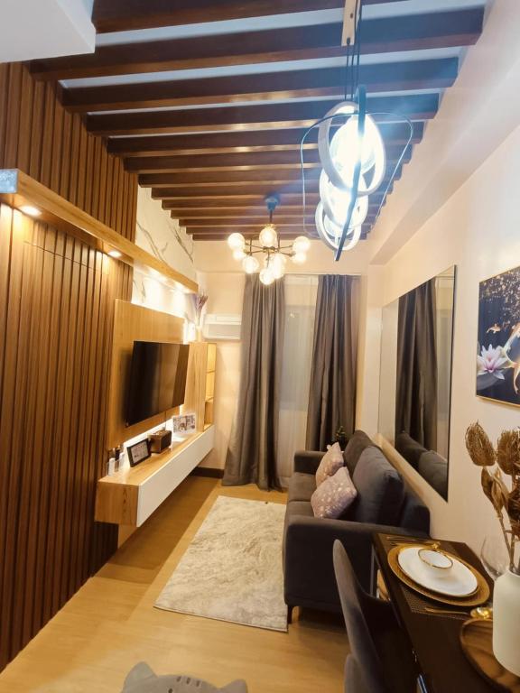 ein Wohnzimmer mit Sofa und Fernseher in der Unterkunft Regalia's Pod in Trece Martires