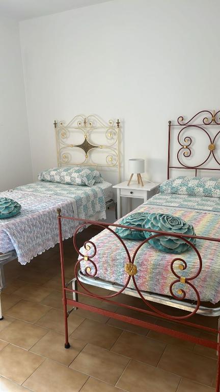 Un dormitorio con dos camas y dos mesitas de noche. en La casa di Paola, en San Benedetto del Tronto