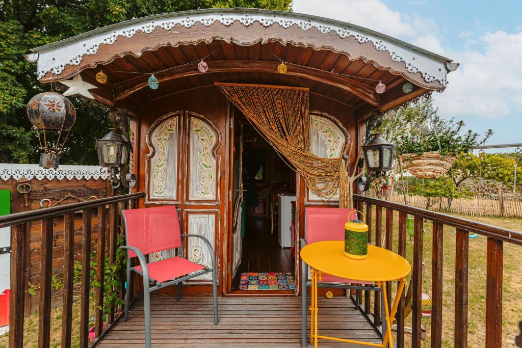 - un kiosque avec une table et des chaises sur une terrasse dans l'établissement Roulotte la casetta Rita, à Chambon