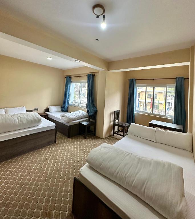 MuktināthHotel Siddhartha & Khanglo Thakali Bhancha Ghar的有两张床和一张沙发的酒店房间
