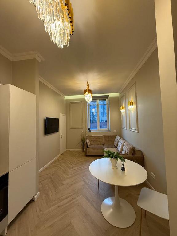 un soggiorno con un tavolo e un divano di Centre GRANT Apartment a Klaipėda