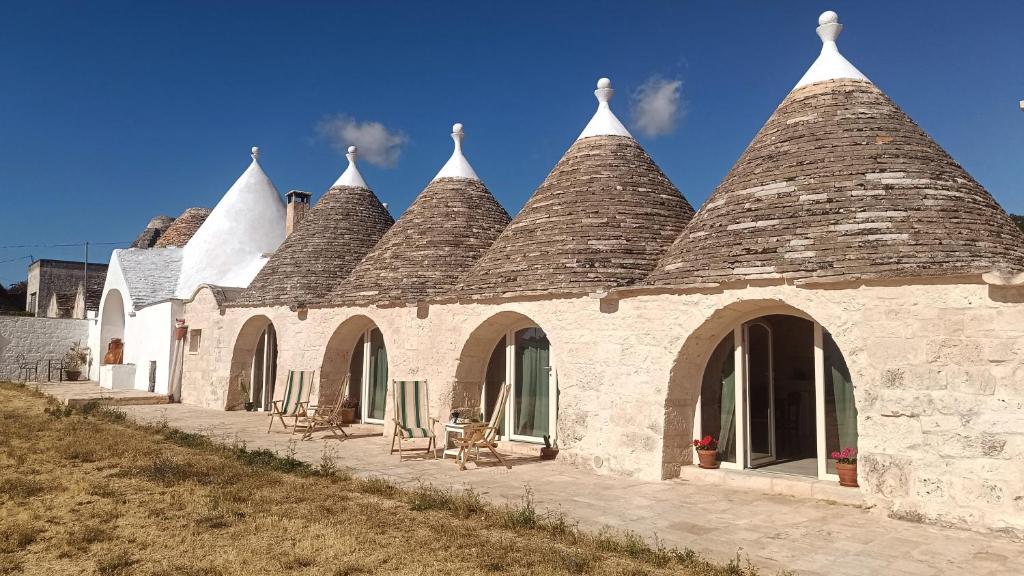 a building with a bunch of spires on it at I Trulletti del Gelso a Masseria Santalachicca in Masseria Orimini