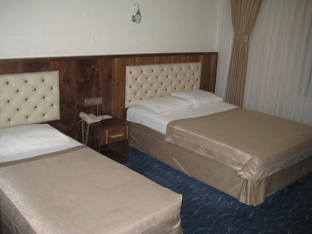 a hotel room with two beds and a telephone at Miroglu Hotel in Diyarbakır