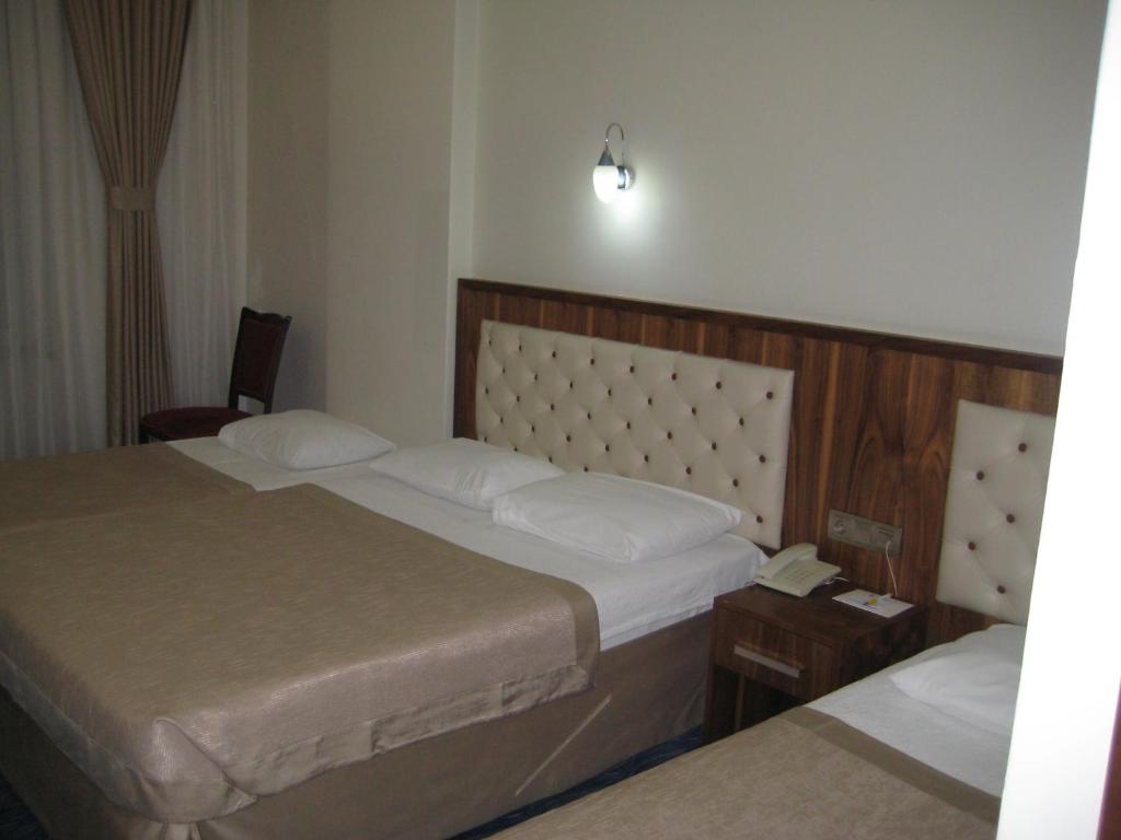 Postel nebo postele na pokoji v ubytování Miroglu Hotel