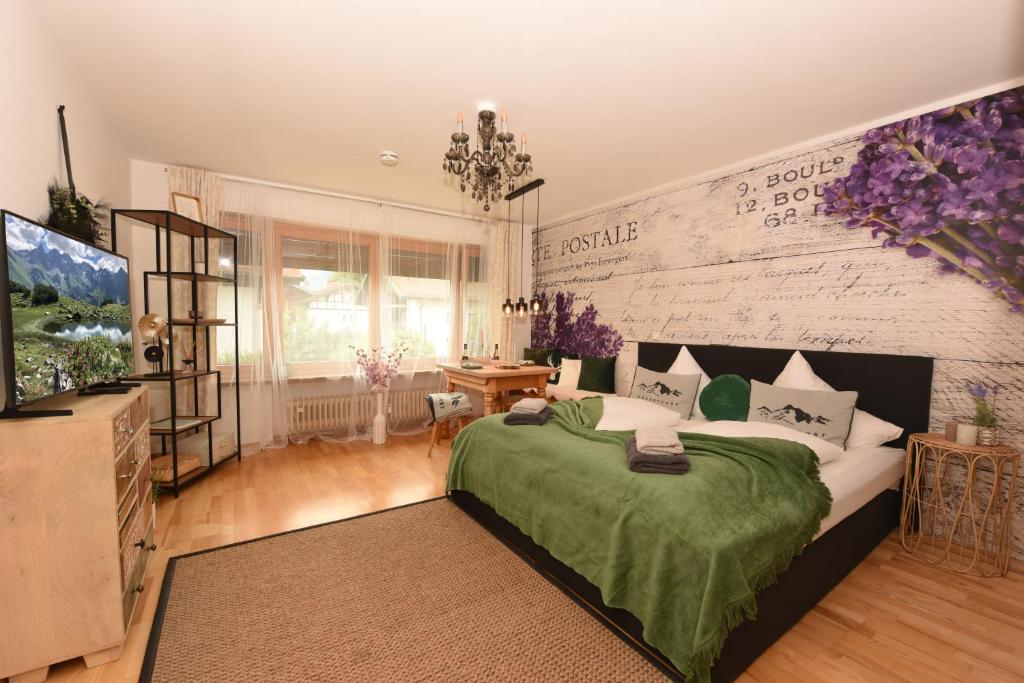 a bedroom with a large bed and a tv at Ferienwohnung Lavendel in Oberstdorf