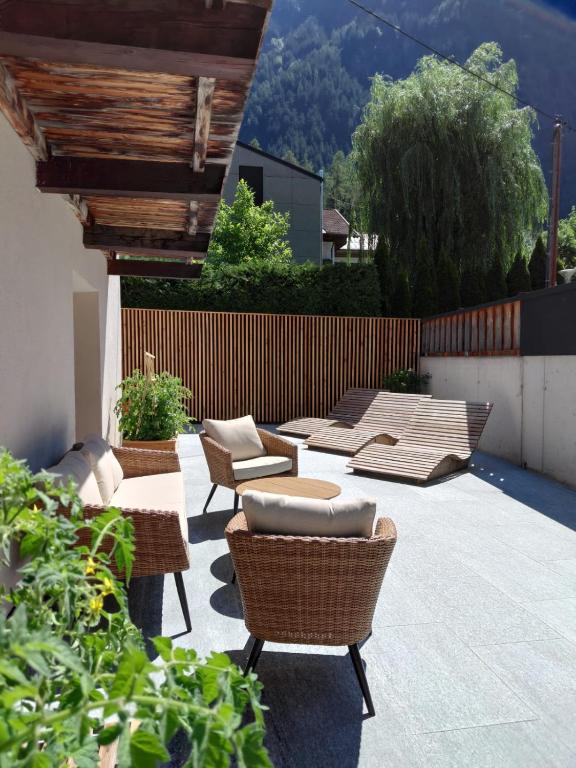 a patio with chairs and tables and a fence at Haus Gstrein in Oetz