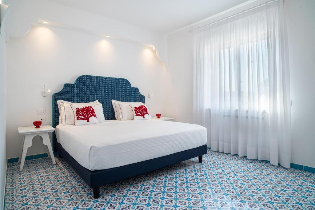 ein Schlafzimmer mit einem blau-weißen Bett und einem Fenster in der Unterkunft Lea Residenza Mediterranea Paestum in Paestum