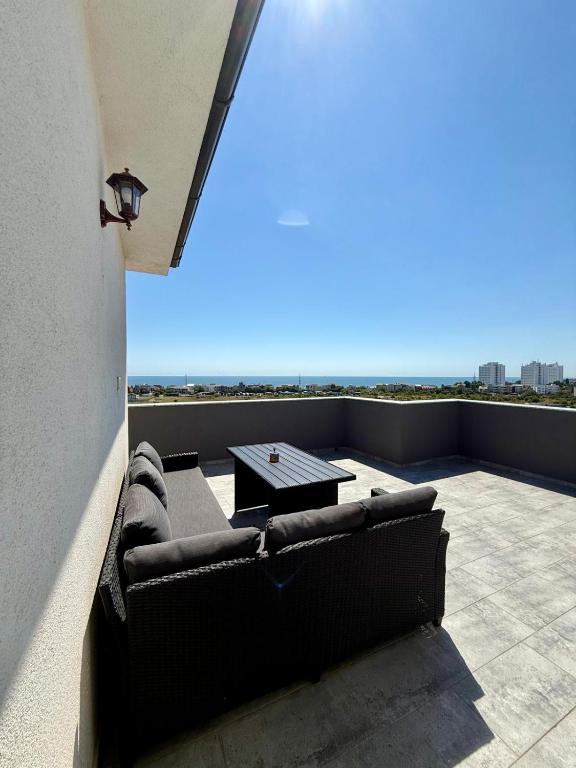 a couch sitting on top of a balcony with a table at Apartament Lucas in Agigea