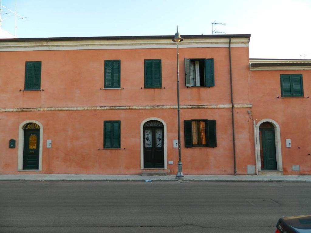 a orange building with windows and doors on a street at Michelino in Florinas