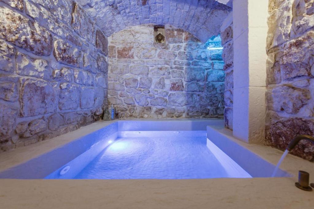 a blue bath tub in a room with a stone wall at Casa Sea La Vie in Ostuni