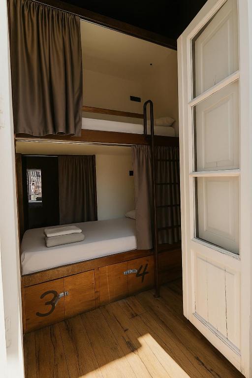 Łóżko piętrowe w pokoju z oknem w obiekcie Black Swan Hostel Sevilla w Sewilli