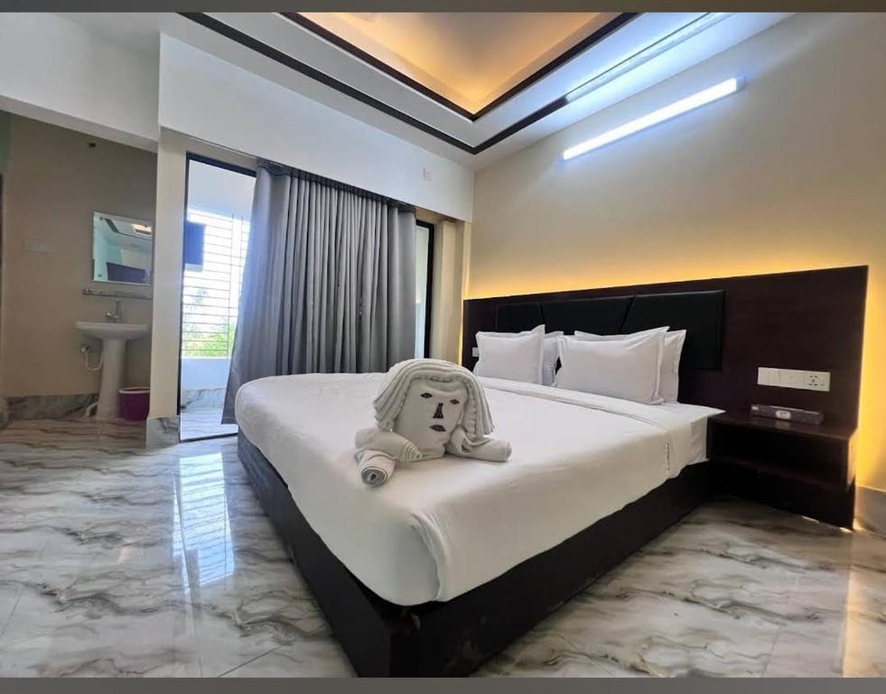 a bed in a hotel room with a stuffed animal on it at The Vacation Inn Hotel & Resort in Bāndarban