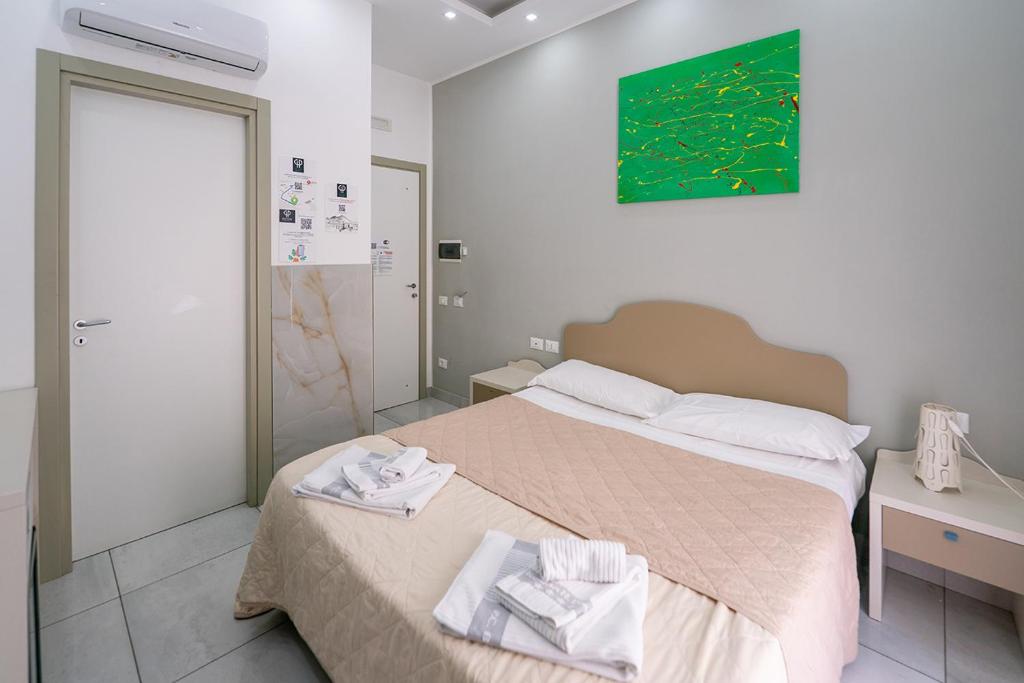 a bedroom with a bed with two towels on it at Royal H Umberto I, Napoli Centro, by ClaPa Group in Naples