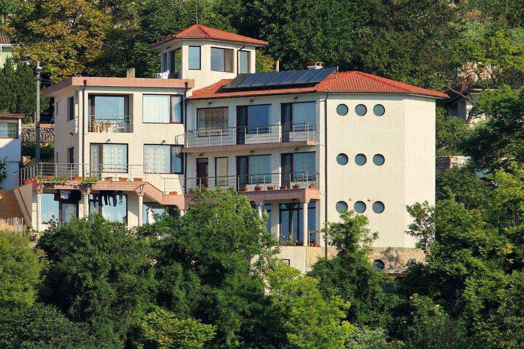 a large white building with a red roof at Guest Rooms Sea View in Balchik