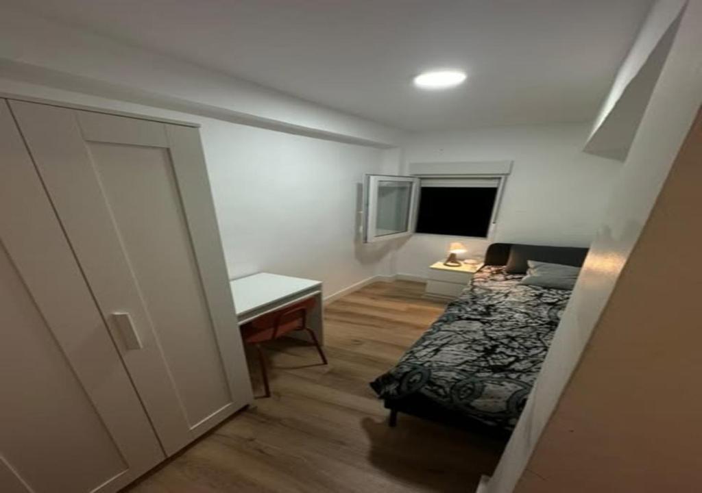 a bedroom with a bed and a desk and a table at alojamiento near everything in Valencia