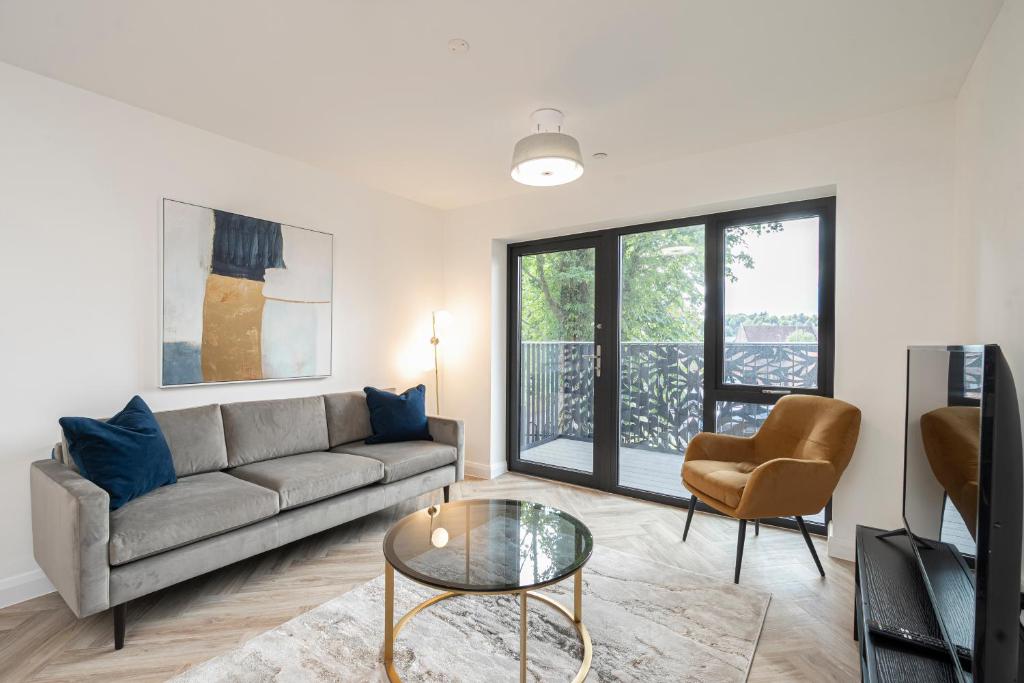 ゴダルマイニングにあるBirchgrove Pepperpot House Exclusively for 65sのソファとガラスのテーブルのあるリビングルーム