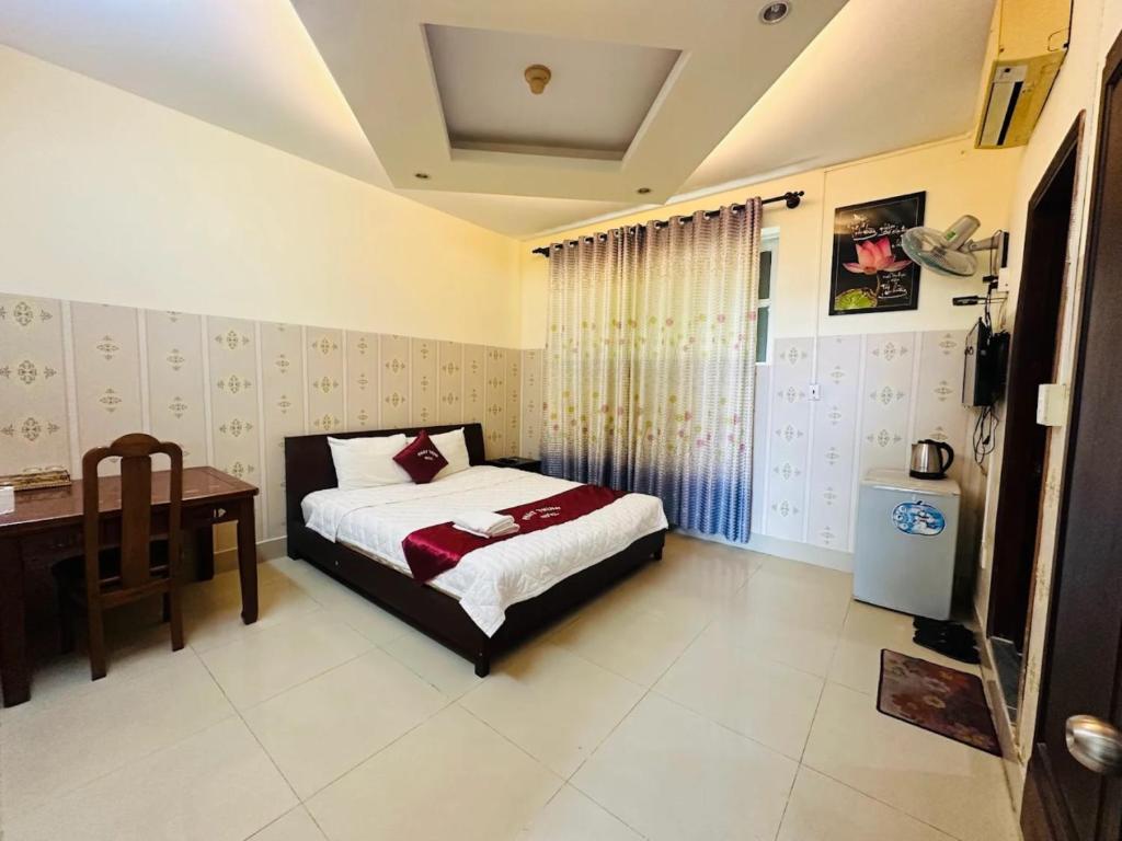 a bedroom with a bed and a desk in it at Phát Thịnh Hotel in Ho Chi Minh City