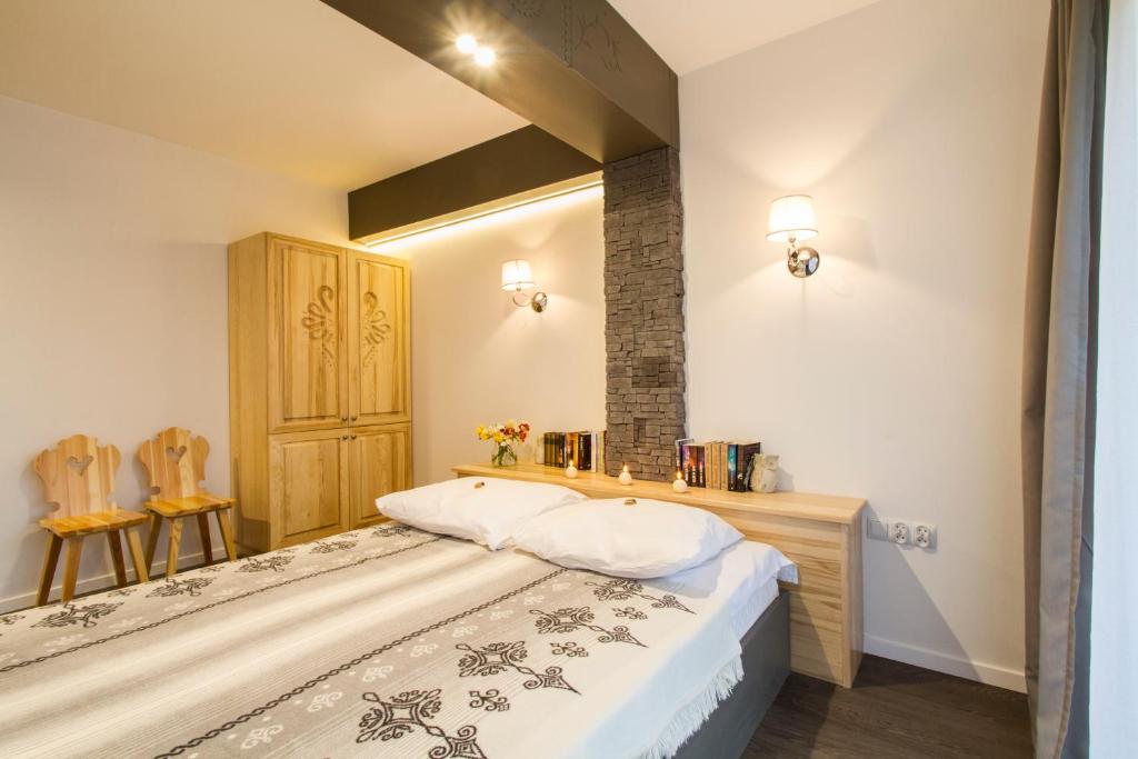 A bed or beds in a room at Zakopane Apartamenty Skibówki