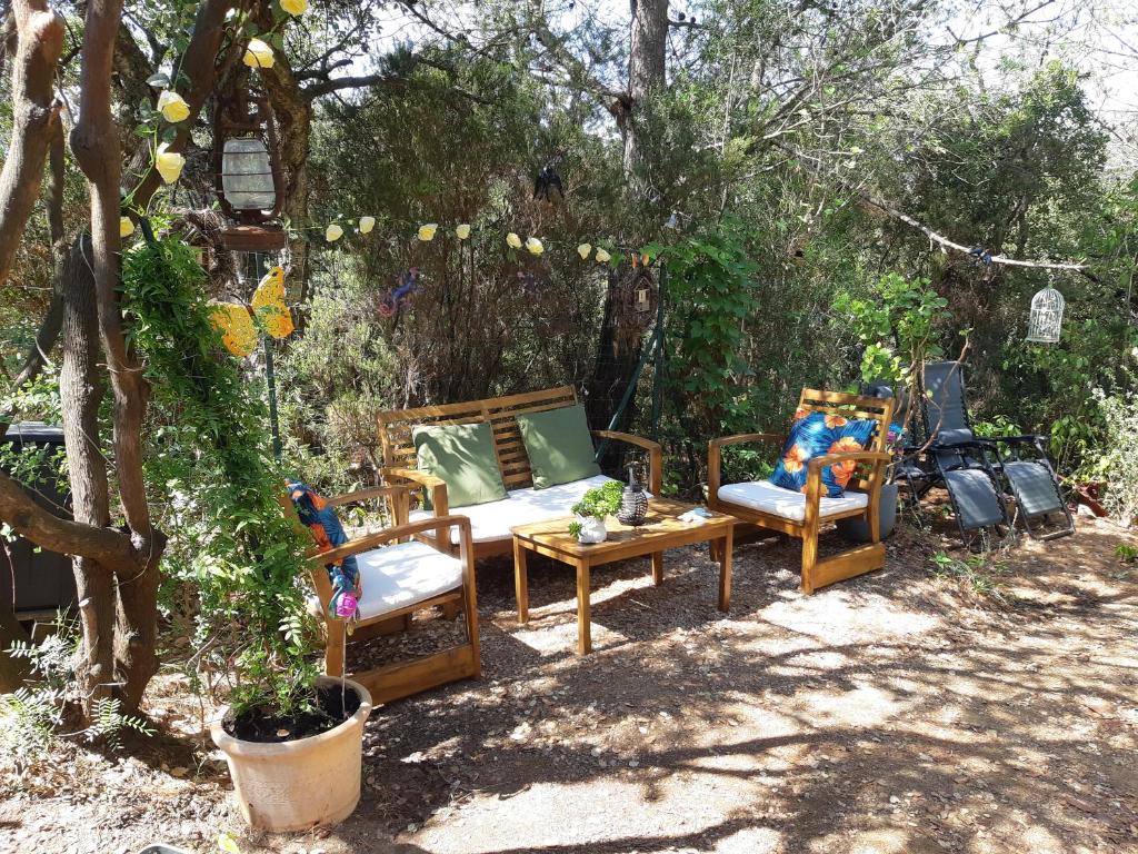 un groupe de chaises et une table dans une cour dans l'établissement Roulotte Fenouillet, à Hyères