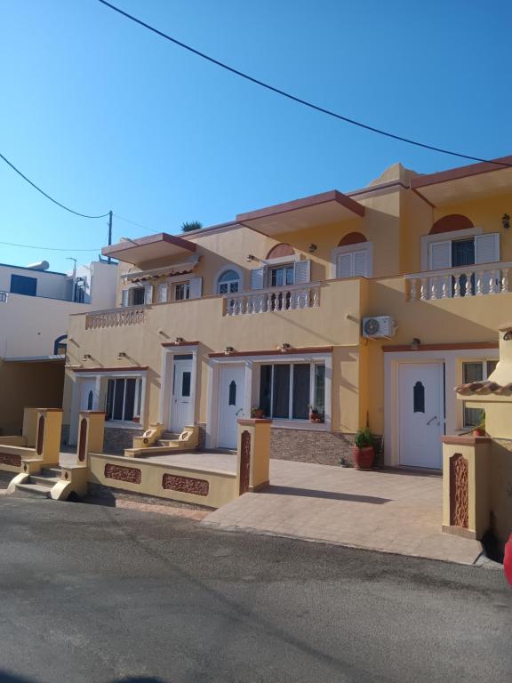 a large yellow building with white doors and windows at Theodore's Mansion Your aristocratic escape in Greece in Panteli