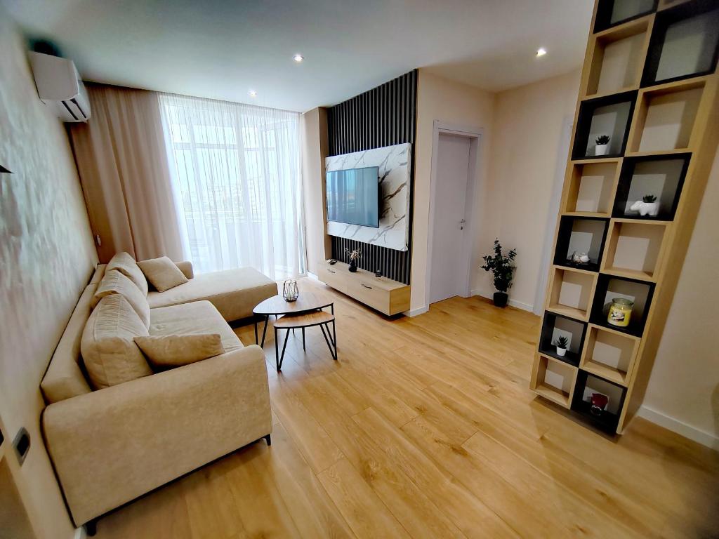 a living room with a couch and a television at MiKi Apartmán Durrës in Durrës